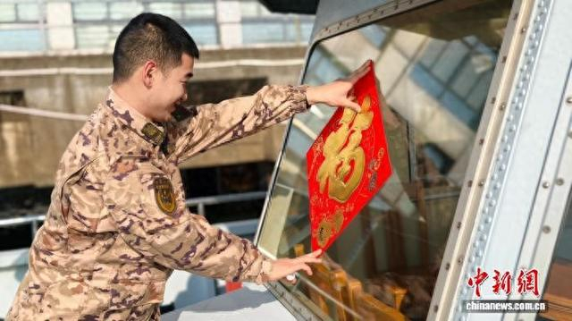 武警杭州支队船艇大队码头点的官兵为巡逻舰贴福字。武警杭州支队 供图