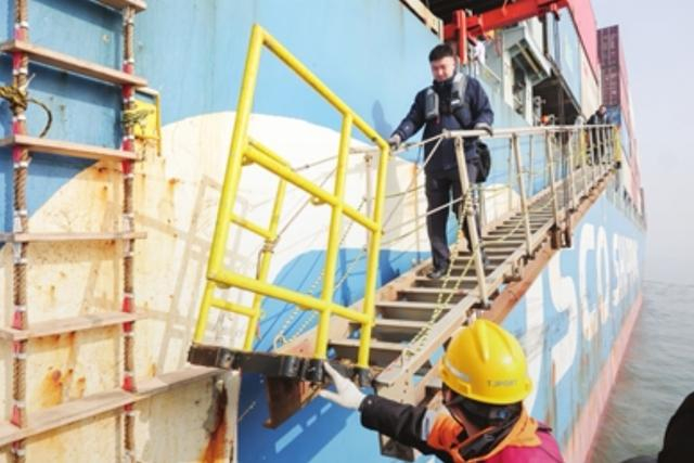 孙勃完成引航指挥后从货轮舷梯下行，准备通过绳梯继续下行至拖轮返回码头。吴迪摄