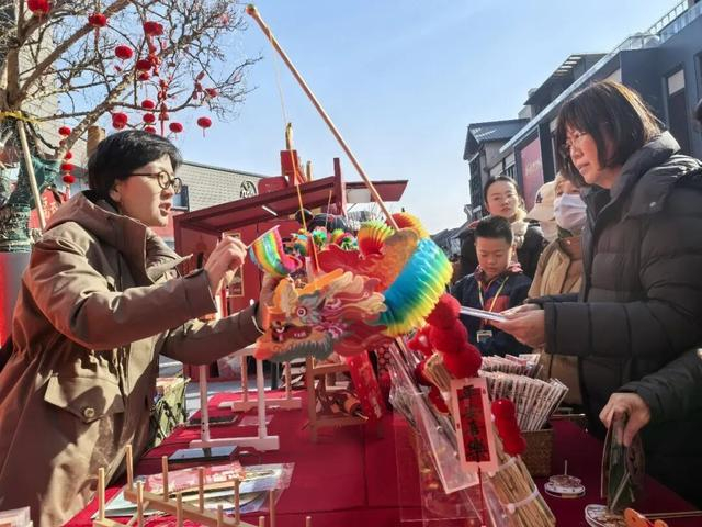 2月12日，隆福寺街区新春市集上，摊主在演示翻里花的玩法。本报记者杨学聪摄