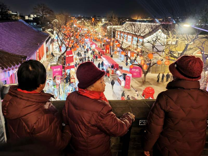 老人俯瞰宛平城内夜景。新京报记者 王巍 摄
