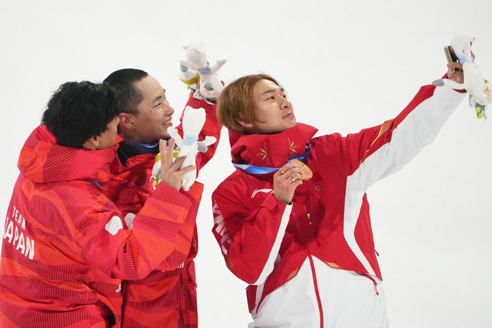 大跳台的颁奖仪式上，苏翊鸣和两位日本选手一起合影