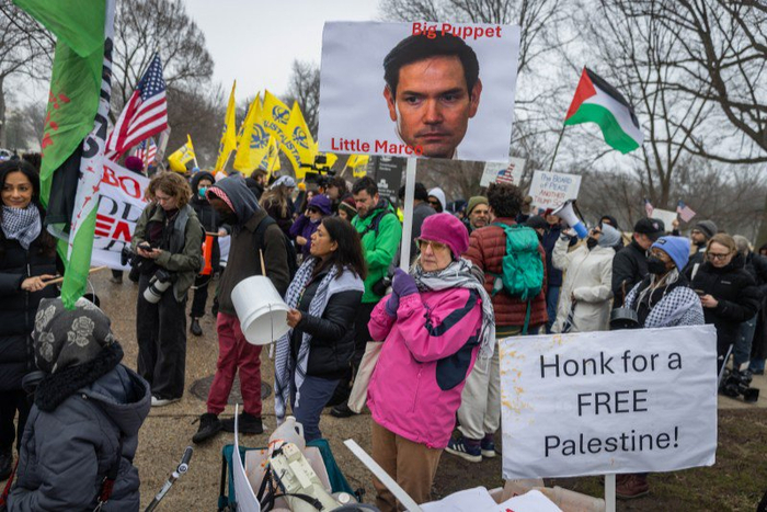 当地时间2026年2月19日，美国华盛顿特区，“和平委员会”首次领导人会议期间，抗议者在会议现场外举牌抗议。 IC Photo