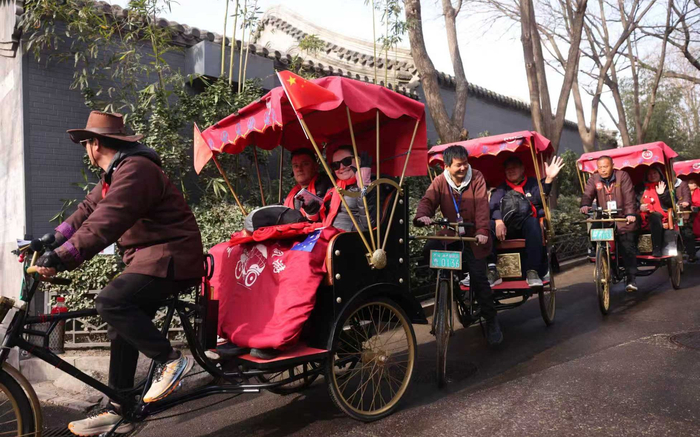 人力三轮车车铃响起，车夫们载着60名澳洲游客游览后海胡同。新京报记者 李木易 摄