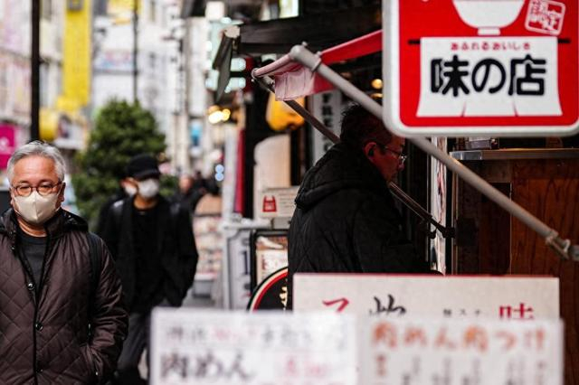 2月20日,在日本东京,顾客在一家餐厅门口购买餐券。新华社记者贾浩成摄
