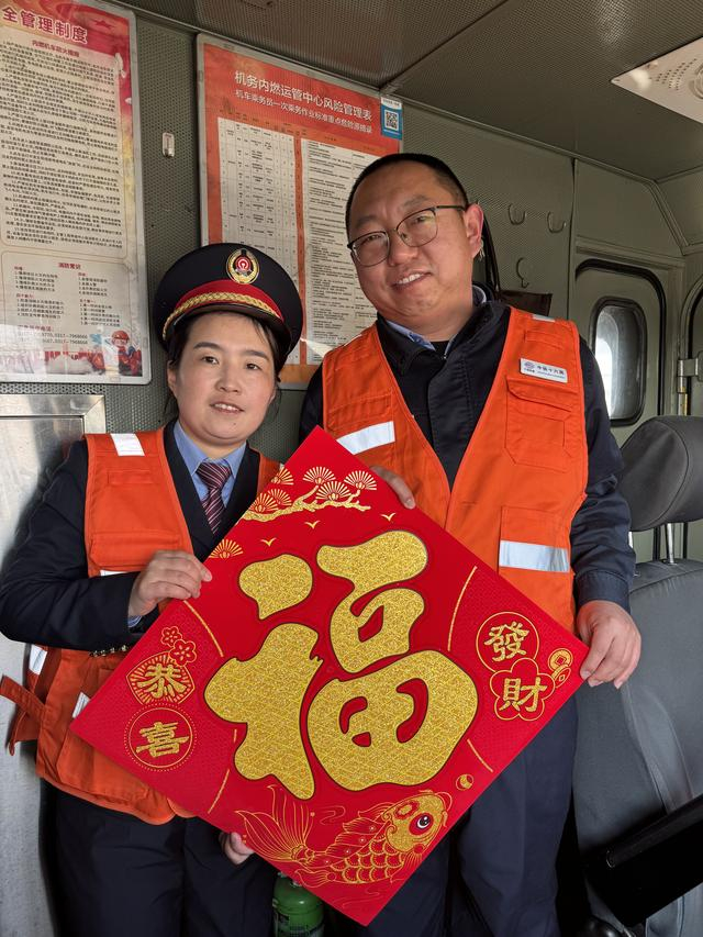 沈利昂和甄文娟在黄骅南站为车组工作人员送“福”字。丰家卫摄