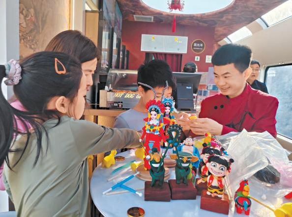 “星光·燕赵号”承德旅游专列上，旅客正在体验捏面人活动。河北日报记者 方素菊摄