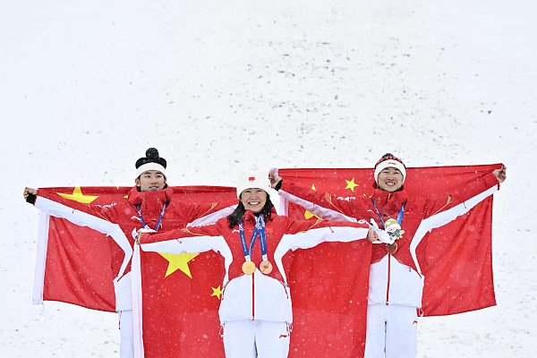 五战冬奥的徐梦桃（中）和丈夫王心迪（右）成为“金牌侠侣”，两人还与李天马一起站上混合团体的领奖台 （视觉中国）