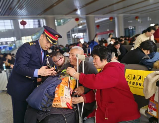 宿州站工作人员为老年旅客查询乘车信息。 祝海侠 摄