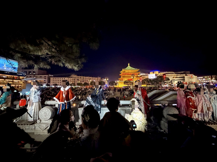 大年初三晚上，西安钟楼前，游人们穿着各式汉服与钟楼合影。新京报记者 丛之翔 摄