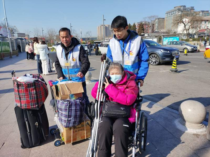 马成朋和马珣睿父子俩共同护送行动不便的旅客。