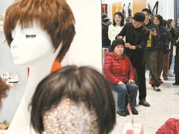             老人试戴假发  本报记者  刘歆  摄          