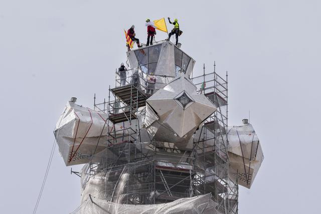 数名工人指引一台起重机安装圣家族大教堂耶稣基督塔顶。视觉中国 图