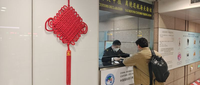 上海浦东机场海关关员为旅客办理离境退税验核业务。受访者供图