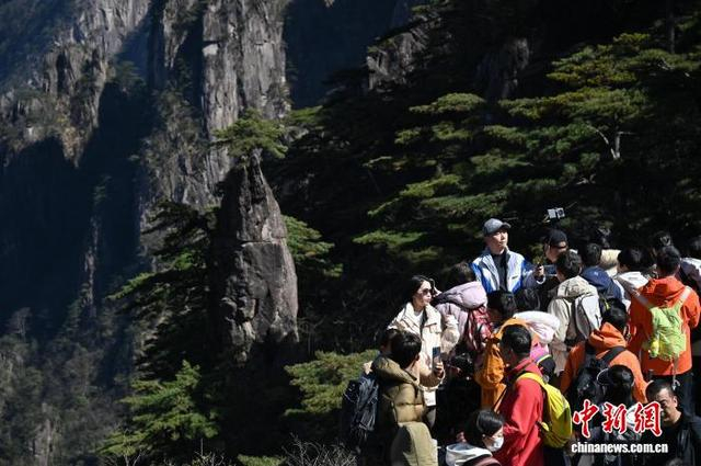 春节期间，游客在黄山“梦笔生花”景点前打卡拍照。 中新社记者 徐雪莹 摄