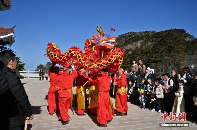春节期间，黄山之巅的舞龙表演吸引众多游客围观。 中新社记者 徐雪莹 摄