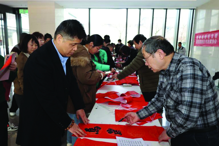 图为书法艺术家为职工写春联。