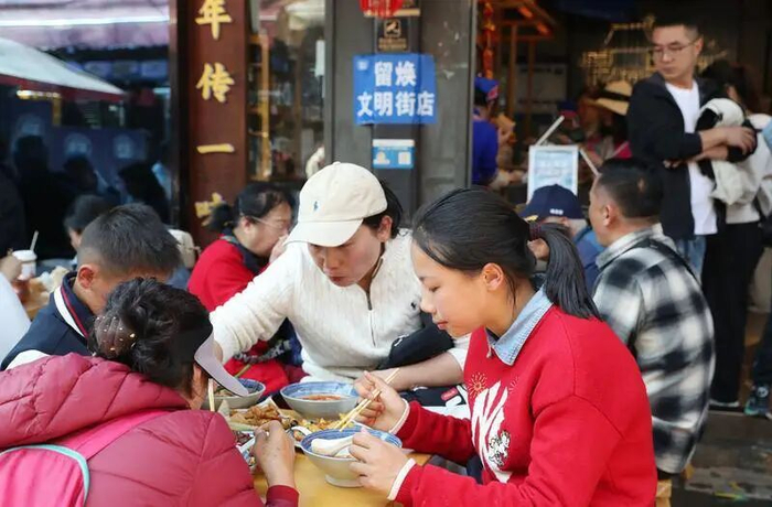 游客品尝云南美食小吃。