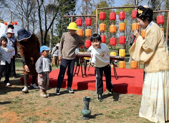 孩子们在国风游园会进行投壶游戏。