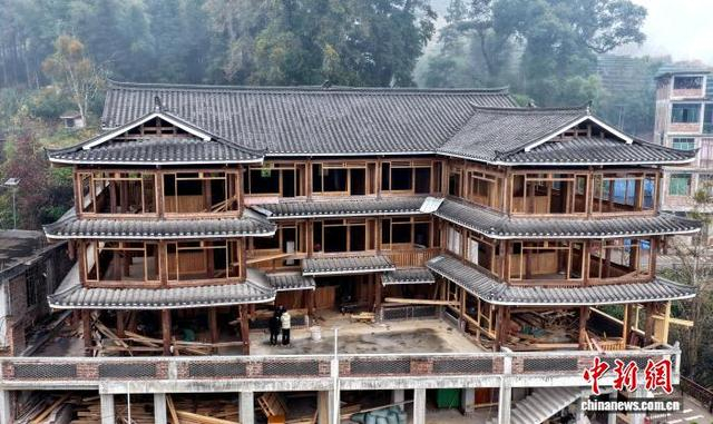 2月19日，广西三江侗族自治县高培村，76岁侗族老人石善章在建的三层双塔式木楼。 龚普康 摄