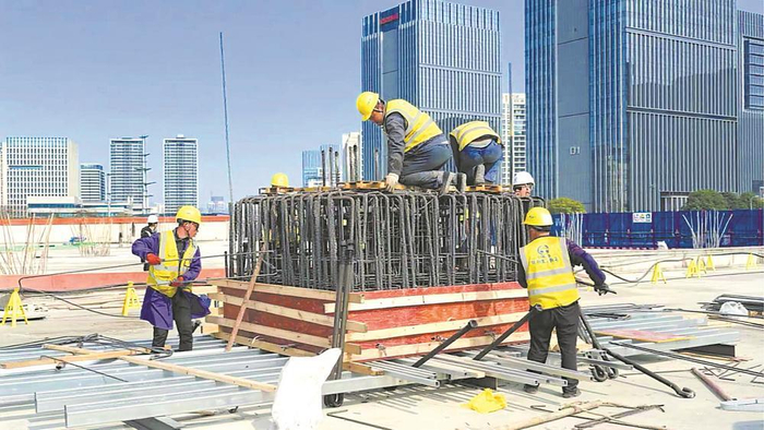     红星路车辆基地建设现场工人们正在安装塔吊基座。