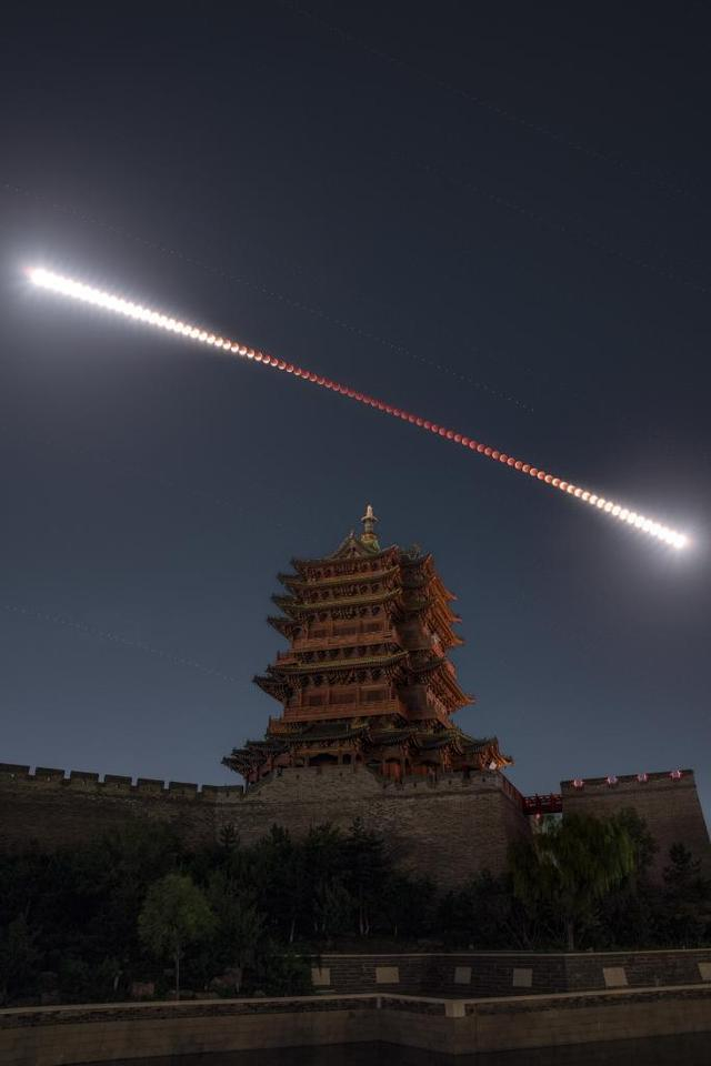 2025年9月7日夜晚至8日凌晨，在山西大同古城墙乾楼拍摄的月全食轨迹（多张堆栈），形似“金箍棒”。新华社发（韩享 摄）