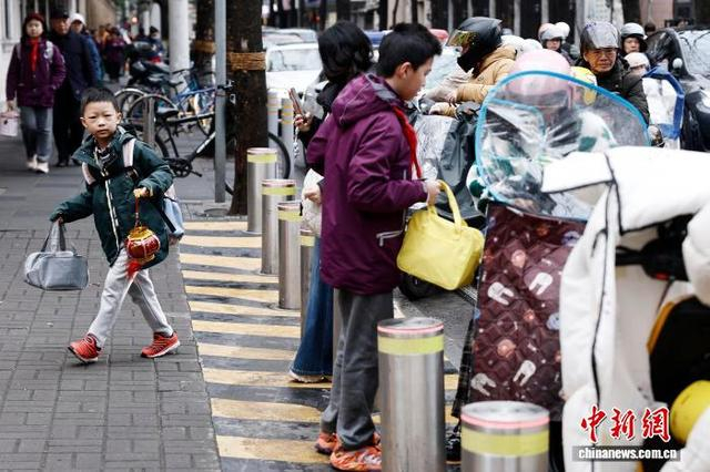 图为在上海市长宁区江苏路第五小学门口，学生提着灯笼进校。中新社记者 殷立勤 摄