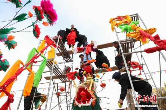 图为匠人们将孩童绑束于高台上。中新社记者 马铭言 摄 