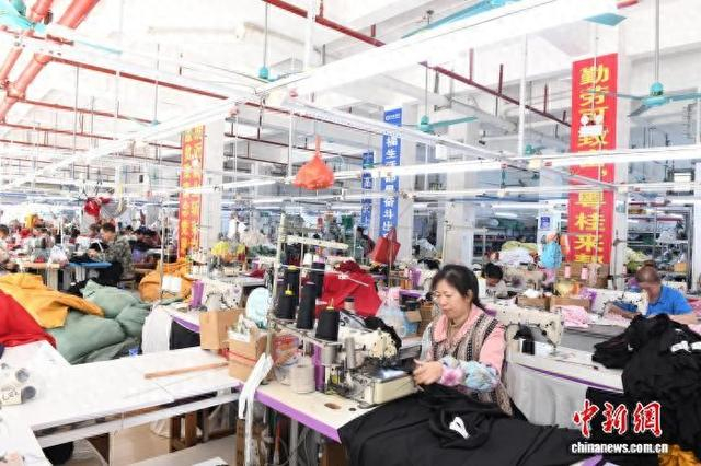 图为闭丽勤和工友们在车间赶制成衣等产品。林浩 摄