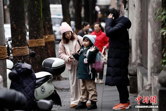 图为在上海市长宁区江苏路第五小学门口，家长送学生上学。中新社记者 殷立勤 摄
