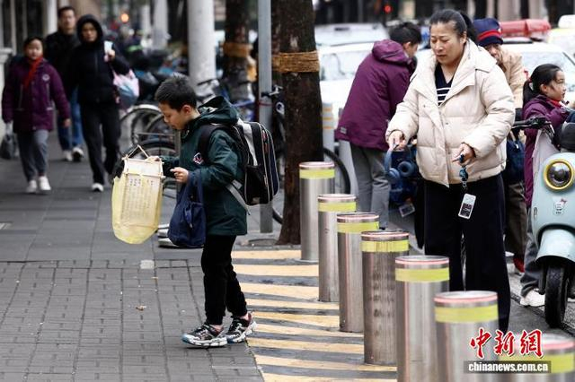 图为在上海市长宁区江苏路第五小学门口，学生提着灯笼进校。中新社记者 殷立勤 摄