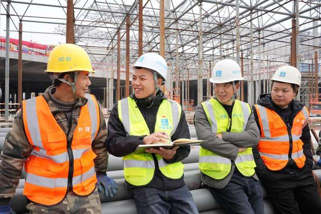 全国人大代表、中建五局总承包公司项目质量总监邹彬（左二）在施工现场调研工友意见。受访者供图