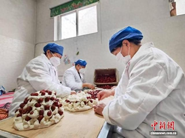 山西长治上党区八义镇石后堡村的蒸馍加工坊内暖意融融、一派繁忙，村民们正赶制传统灯糕。 赵彦杰 摄