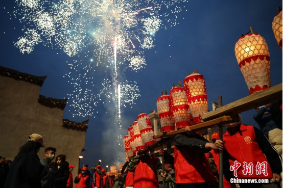 2025年2月，江西南昌，村民们扛着由梅烛灯组成的板凳龙穿行于街道之中。（资料图）中新社记者刘思伟摄