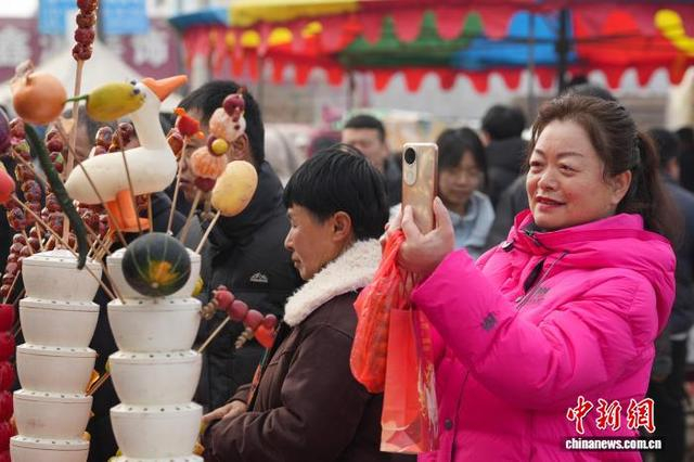 图为糖墩会上，游客拍摄待加工的糖墩儿。 韩慧峰 摄