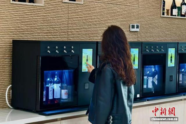 游客在智能自助品鉴设备购买贺兰山东麓葡萄酒。 王婧雅 摄