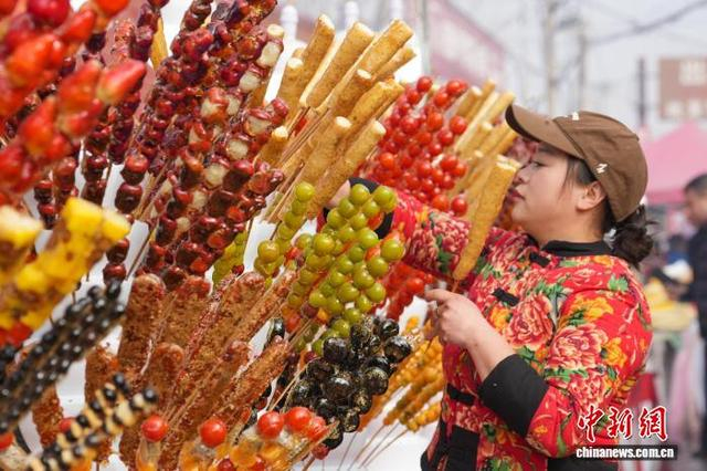 图为糖墩会上，游客正在选糖墩儿。 韩慧峰 摄