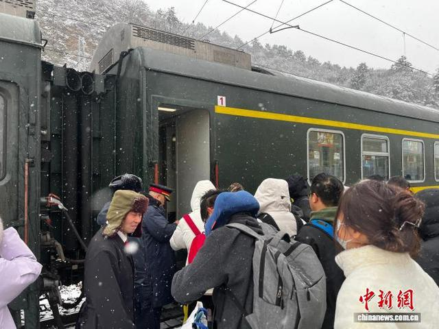 承德车务段客运乘务车间值乘的4472次列车停靠滦平站，乘务人员组织旅客乘降。承德车务段 供图