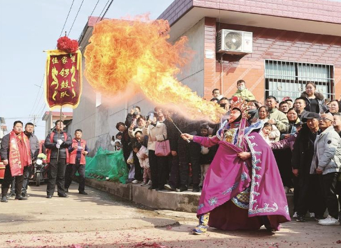 社火巡游中的喷火表演。 本报记者 马昭 摄