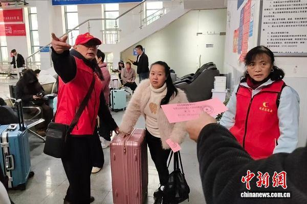 志愿者正在为返岗人员搬运行李、指引乘车。受访者供图