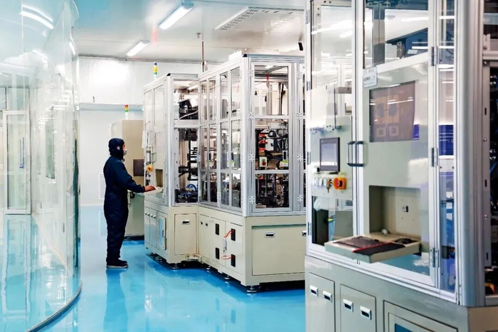 先进能源材料基因工程融合创新（中试）平台内，工程师正在操作叠片机完成芯包叠片工序。图/天府绛溪实验室供
