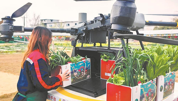     无人机落地后由工作人员完成交接，随即进入区内配送。