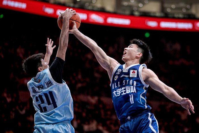 3月7日，大学生联队球员石奎（右）与CBA星锐队球员李悦洲在比赛中拼抢篮板球。新华社记者 江汉 摄