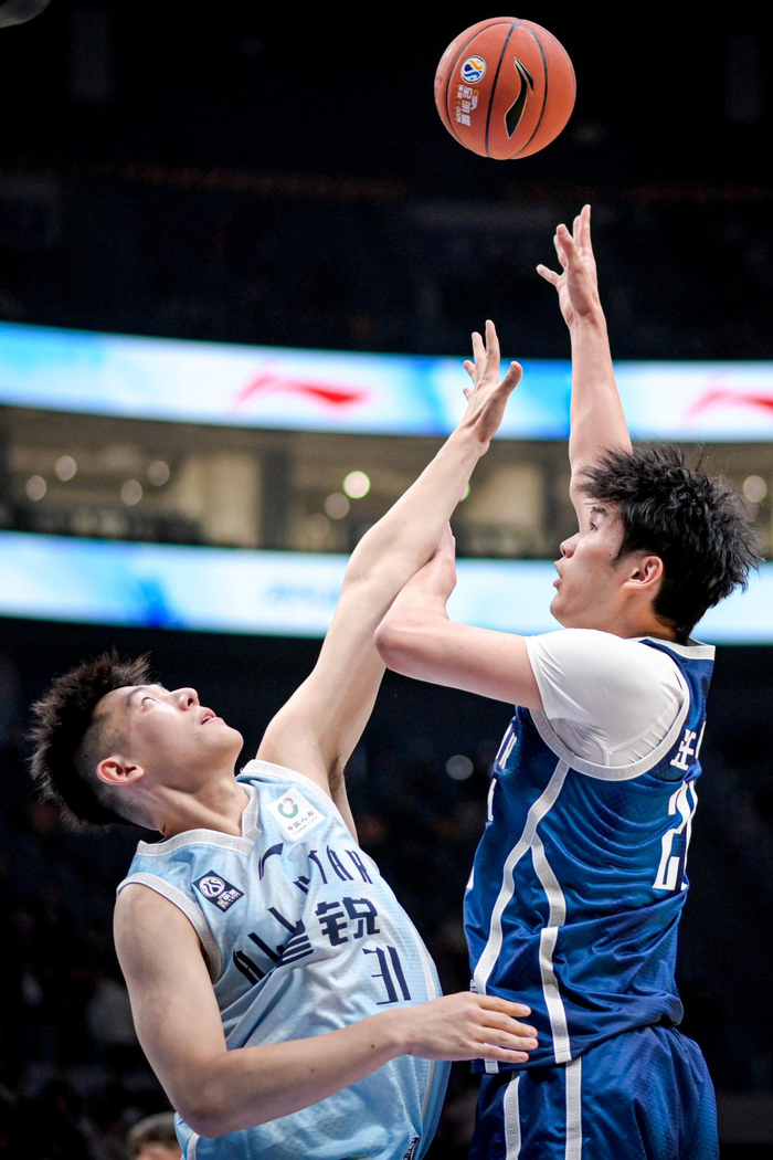 3月7日，大学生联队球员汪志鹏（右）在比赛中投篮。新华社记者 江汉 摄