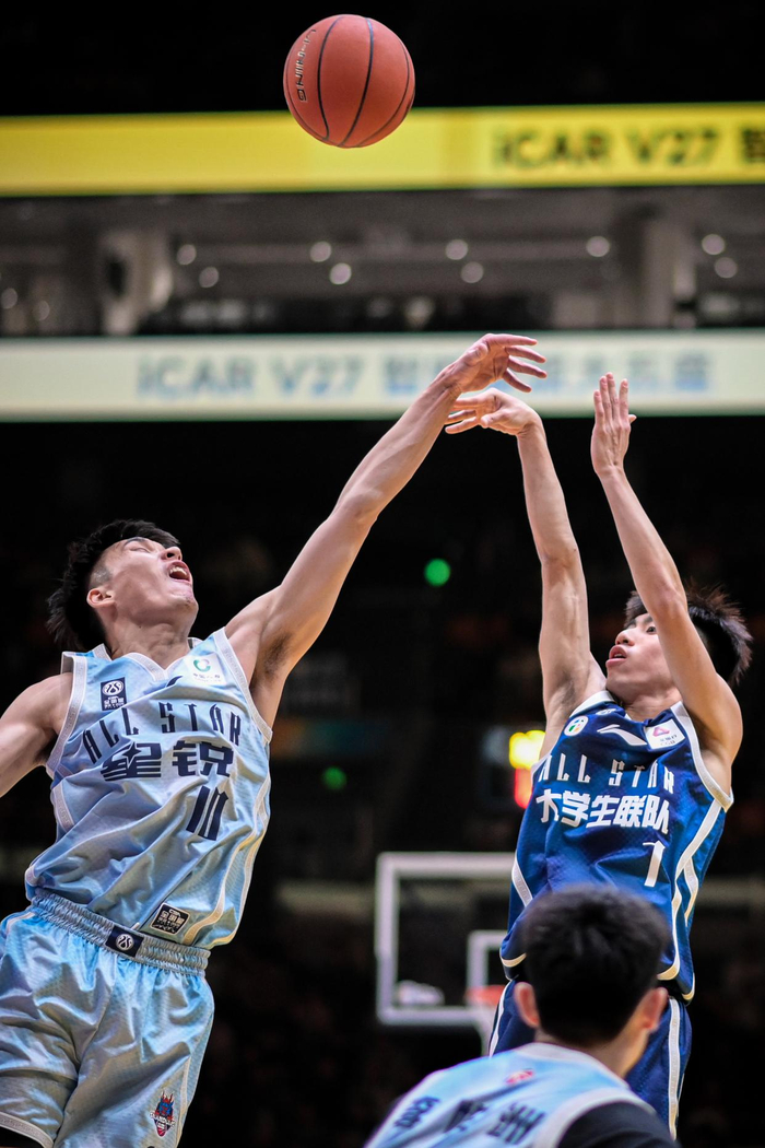 3月7日，大学生联队球员叶润峰（右上）在CBA星锐队球员谢智杰（左）的防守下投篮。新华社记者 江汉 摄