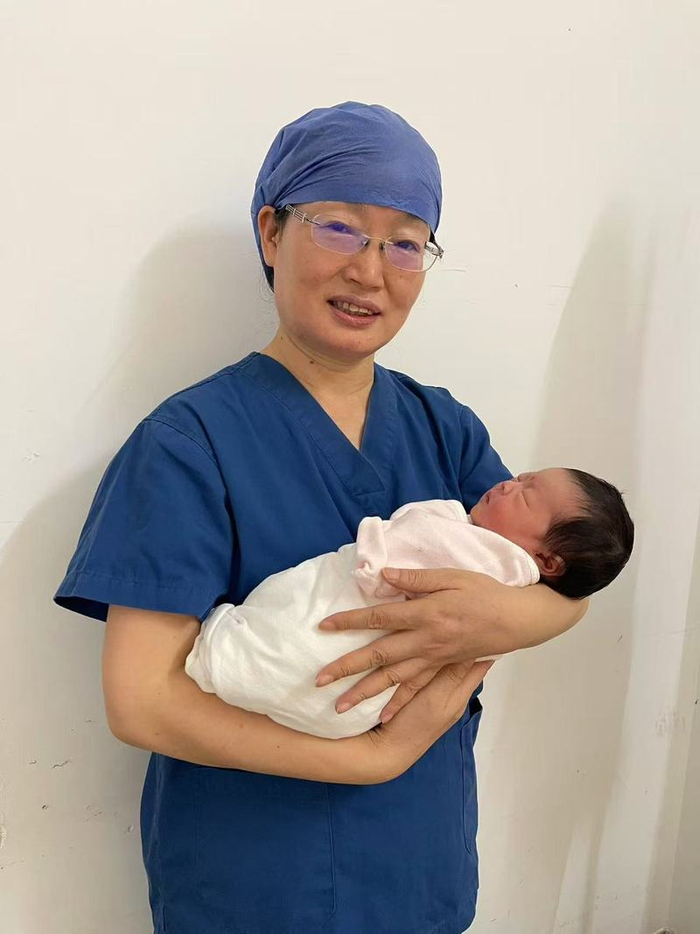 阮祥燕抱着卵巢组织移植患者自然怀孕后诞下的婴儿悠悠。  受访者供图