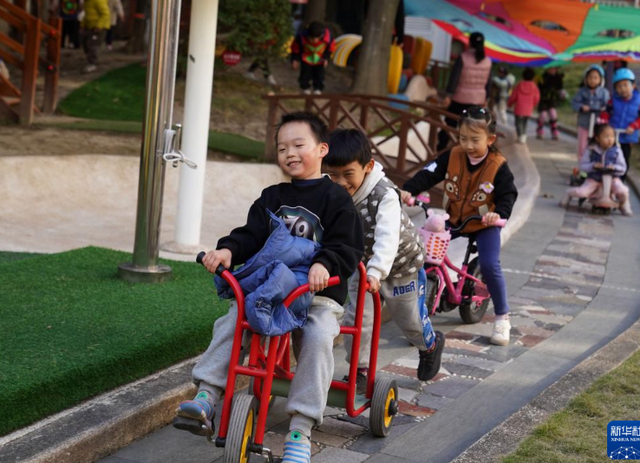 幼儿园内，小朋友在“校园赛道”上骑车。图源：新华社