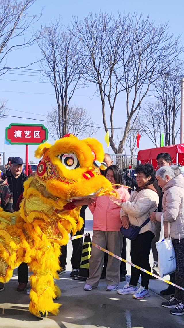 舞狮演员与大集顾客互动。赵冬雪摄