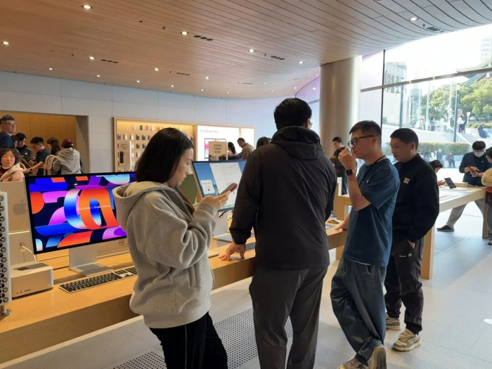 在Mac mini展品前咨询的消费者