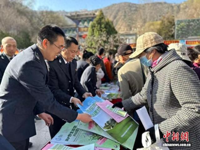 3月12日，2026年甘肃省级义务植树集中宣传活动在兰州市举办。图为相关人员为市民发放宣传册。闫姣 摄