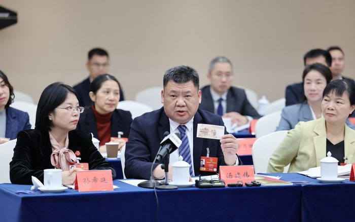 全国人大代表、桂林漓江风景名胜区战略发展处副主任汤建伟在展示20元人民币背面的漓江风光。受访者供图